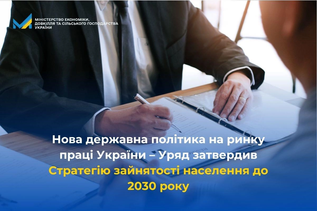 Людина підписує документ на столі, присвячений Стратегії зайнятості населення України до 2030 року